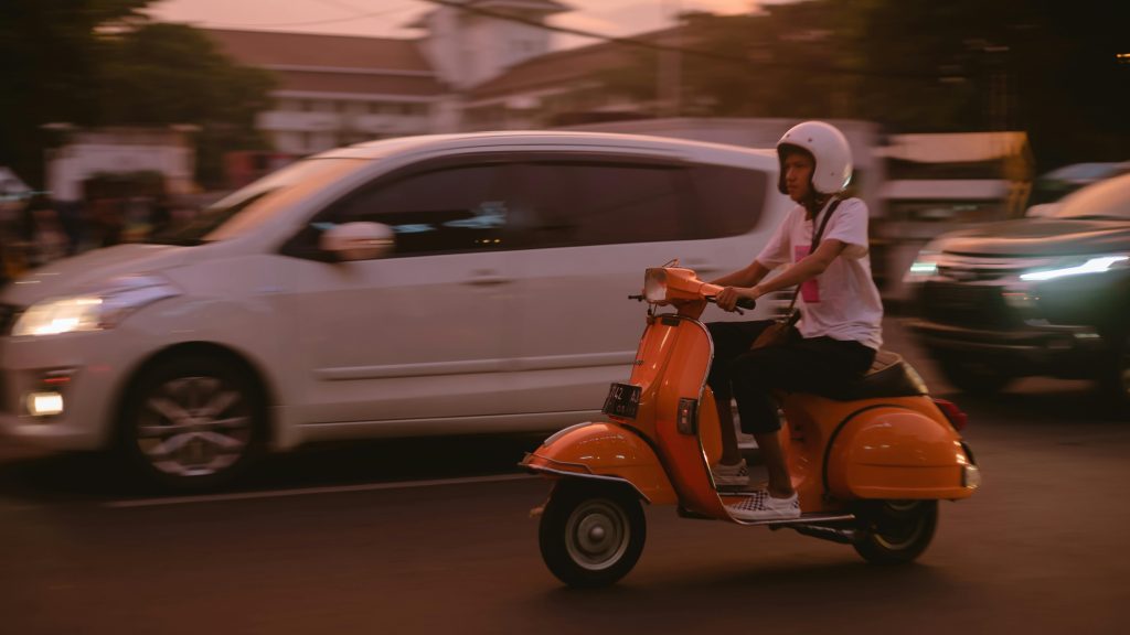 chica conduciendo vespa roja